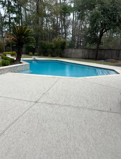 Freeform pool with dark water and rock waterfall feature