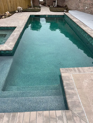 Rectangular pool with green water and stone coping