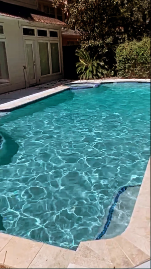 Kidney-shaped pool with spa and brick coping