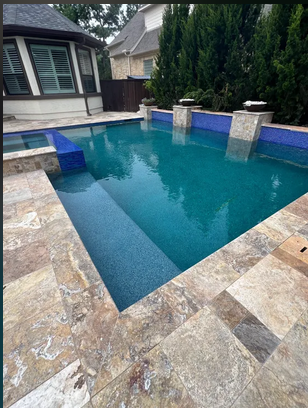 Pool with travertine stone coping and blue tile